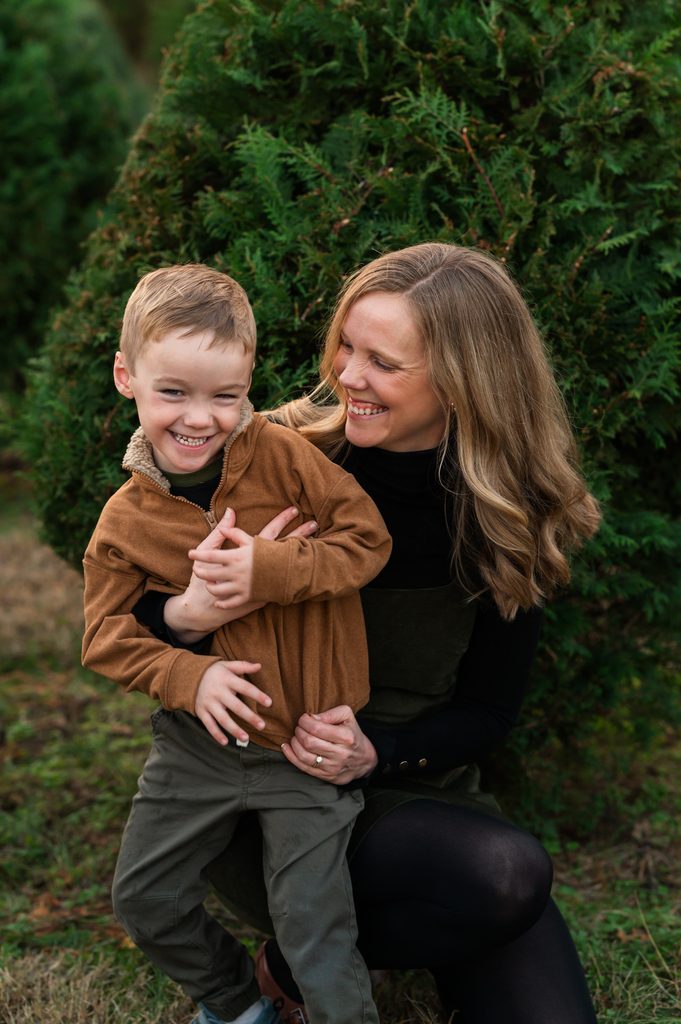 Mom and son laughing together during a Christmas tree farm mini session north of Nashville, TN