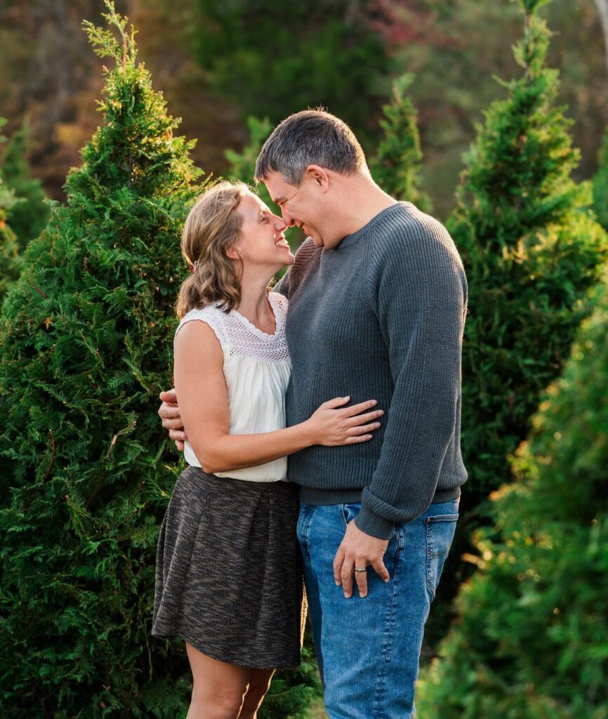 Couple sharing a moment at a Christmas tree farm mini session at Big Sky Farm in Portland, TN