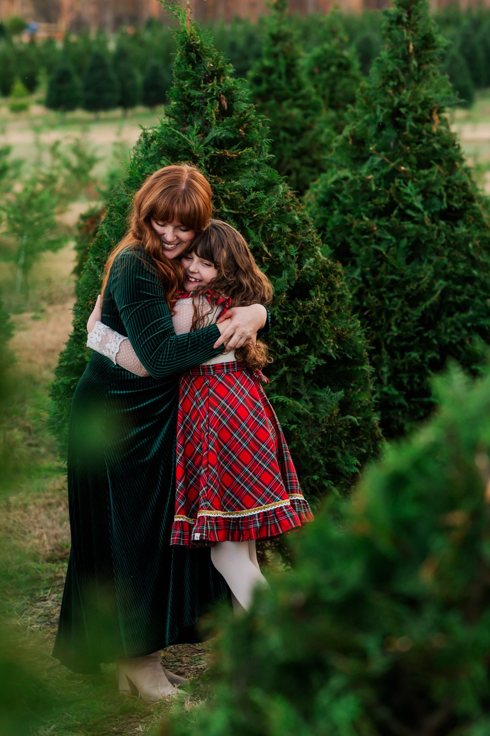 Mom and daughter hug during a Christmas tree farm mini session at Big Sky Farm in Portland, TN